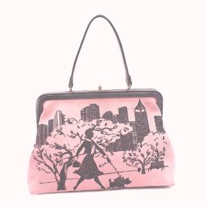 Isabella Fiore pink suede Handbag depicting a woman strolling through a park with a small dog on a leash.